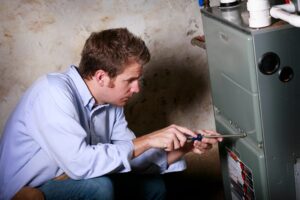 Repairing Furnace With Puddle Of Water Around It